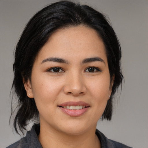 Joyful asian young-adult female with medium  black hair and brown eyes