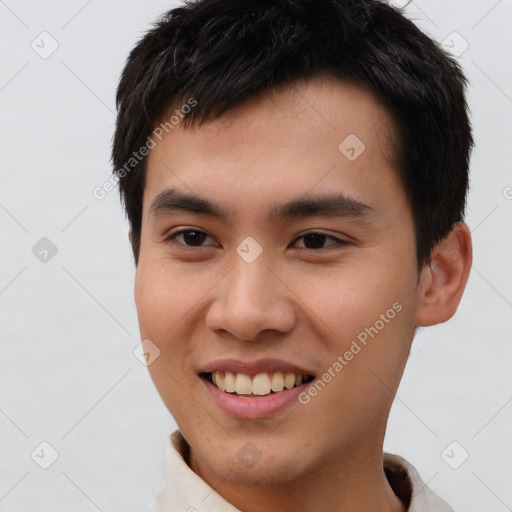 Joyful white young-adult male with short  black hair and brown eyes