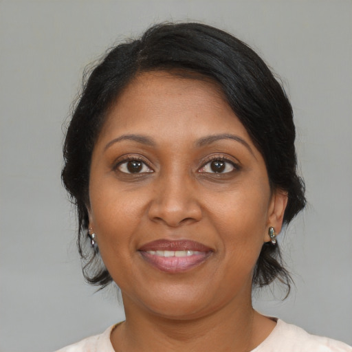 Joyful black adult female with medium  brown hair and brown eyes