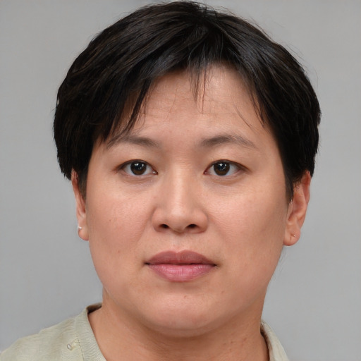 Joyful asian adult female with short  brown hair and brown eyes