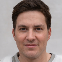 Joyful white adult male with short  brown hair and grey eyes