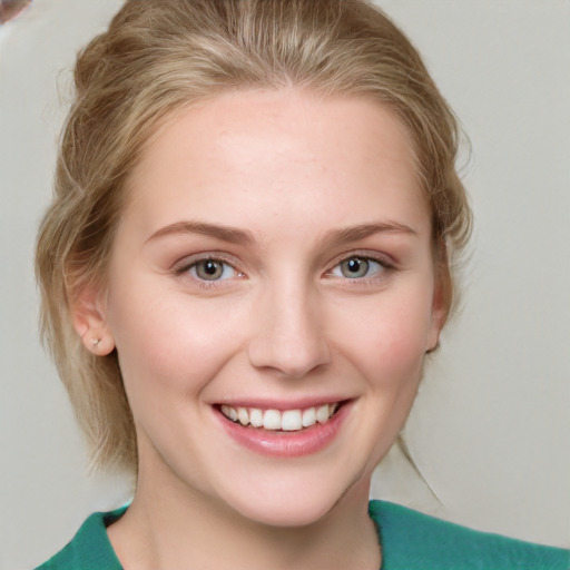 Joyful white young-adult female with medium  brown hair and blue eyes