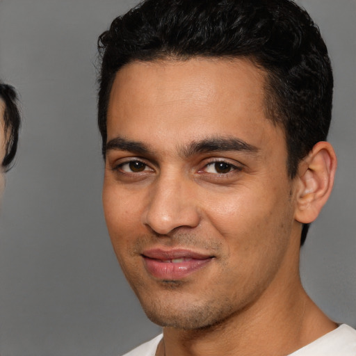 Joyful white young-adult male with short  black hair and brown eyes
