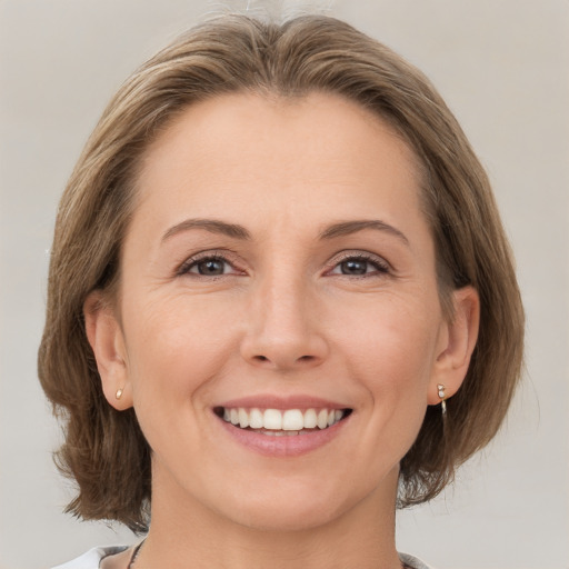 Joyful white adult female with medium  brown hair and brown eyes