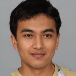 Joyful latino young-adult male with short  brown hair and brown eyes