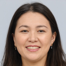 Joyful white adult female with long  brown hair and brown eyes