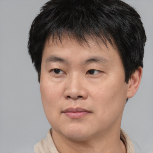 Joyful asian young-adult male with short  brown hair and brown eyes