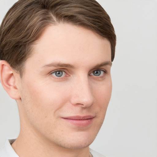 Joyful white young-adult male with short  brown hair and grey eyes