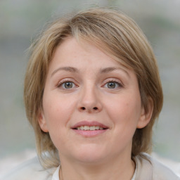 Joyful white adult female with medium  brown hair and blue eyes