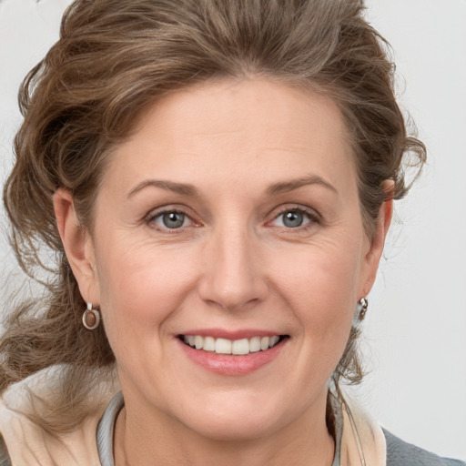 Joyful white adult female with medium  brown hair and grey eyes