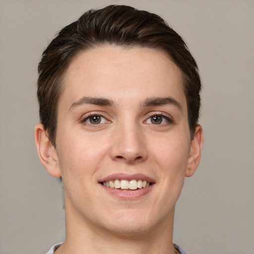 Joyful white young-adult male with short  brown hair and grey eyes