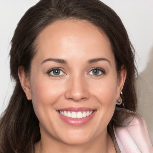 Joyful white young-adult female with long  brown hair and brown eyes