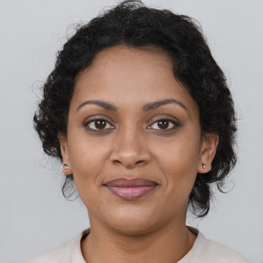Joyful black young-adult female with short  brown hair and brown eyes