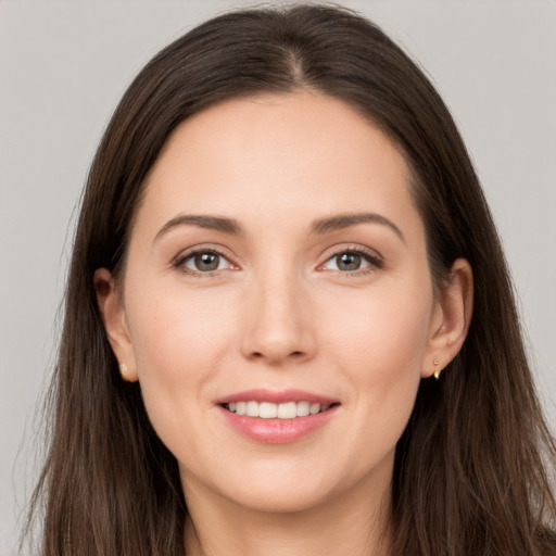 Joyful white young-adult female with long  brown hair and brown eyes