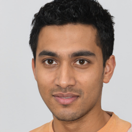 Joyful latino young-adult male with short  black hair and brown eyes