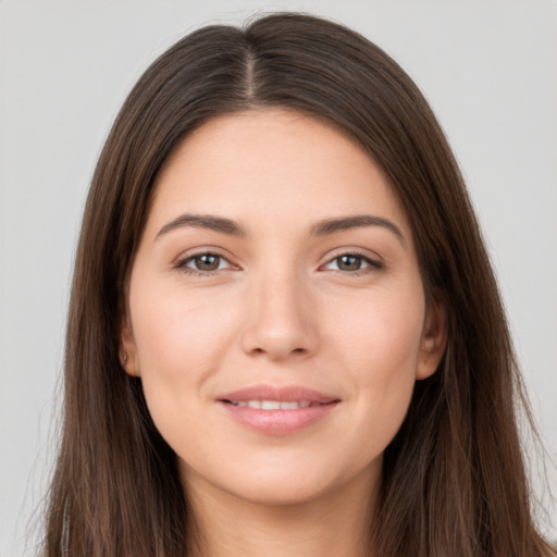 Joyful white young-adult female with long  brown hair and brown eyes