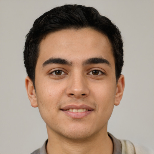 Joyful latino young-adult male with short  black hair and brown eyes