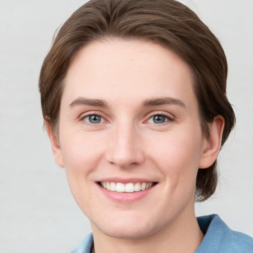 Joyful white young-adult female with short  brown hair and grey eyes