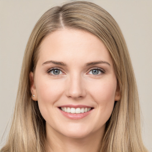 Joyful white young-adult female with long  brown hair and grey eyes