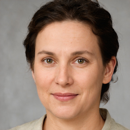 Joyful white adult female with medium  brown hair and green eyes