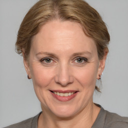 Joyful white adult female with medium  brown hair and grey eyes