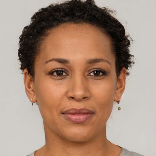 Joyful black adult female with short  brown hair and brown eyes