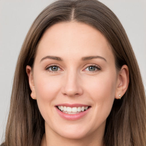 Joyful white young-adult female with long  brown hair and grey eyes