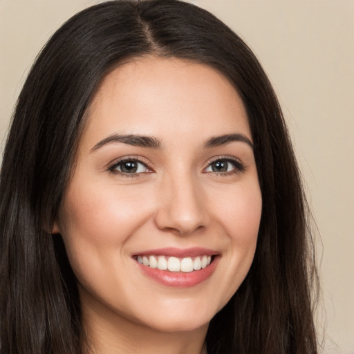 Joyful white young-adult female with long  brown hair and brown eyes