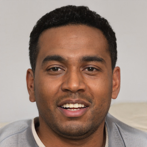 Joyful black young-adult male with short  black hair and brown eyes