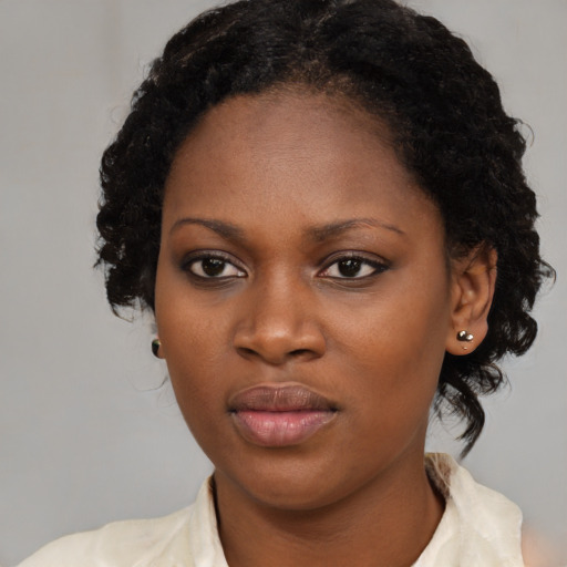 Joyful black young-adult female with medium  brown hair and brown eyes