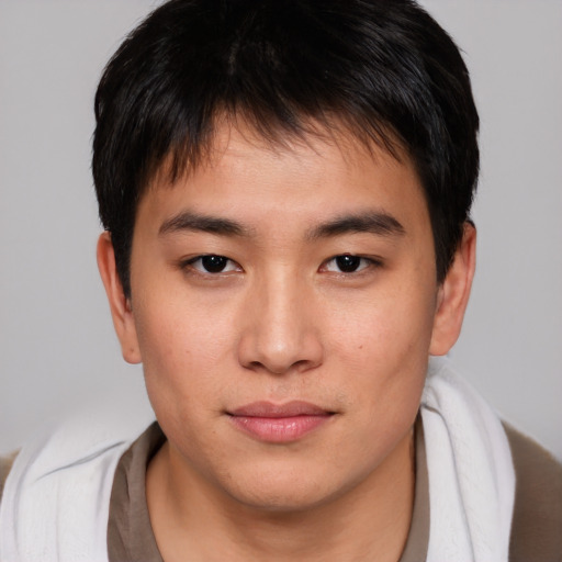 Joyful asian young-adult male with short  brown hair and brown eyes