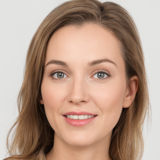 Joyful white young-adult female with long  brown hair and grey eyes