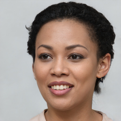 Joyful black young-adult female with short  brown hair and brown eyes