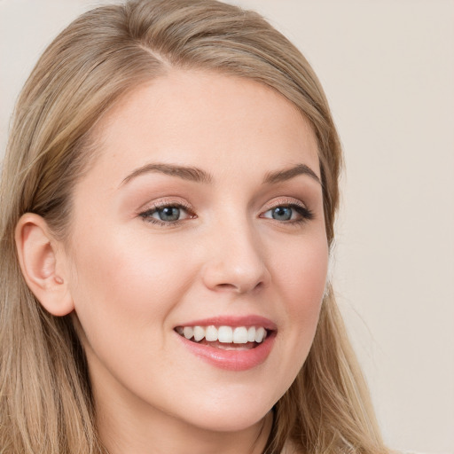 Joyful white young-adult female with long  brown hair and blue eyes