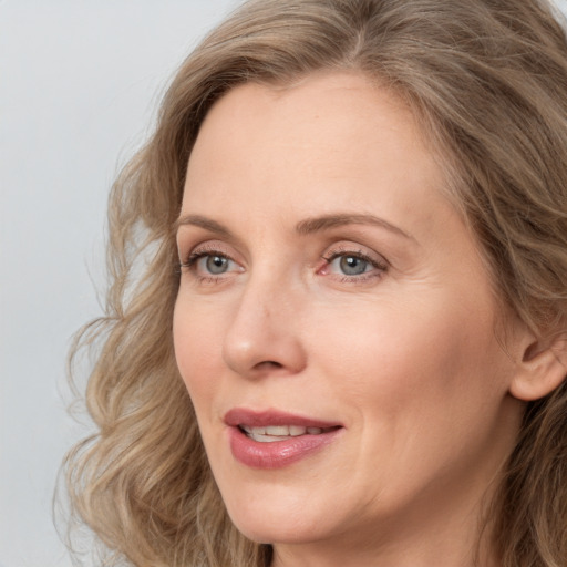 Joyful white adult female with medium  brown hair and blue eyes