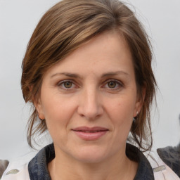 Joyful white adult female with medium  brown hair and grey eyes