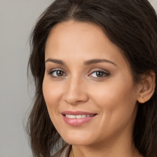 Joyful white young-adult female with long  brown hair and brown eyes