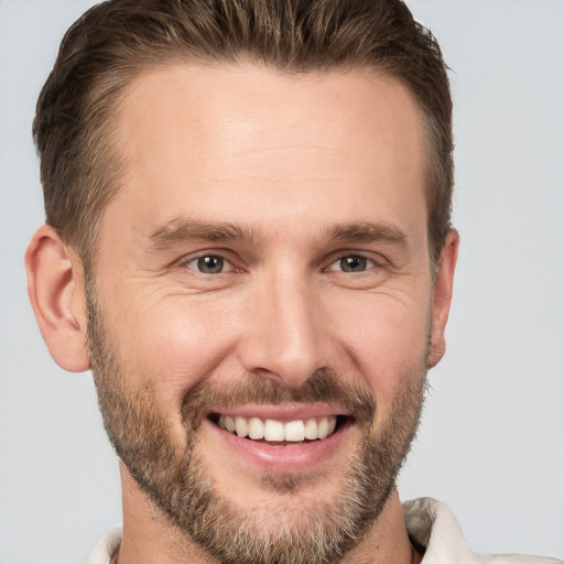 Joyful white adult male with short  brown hair and brown eyes