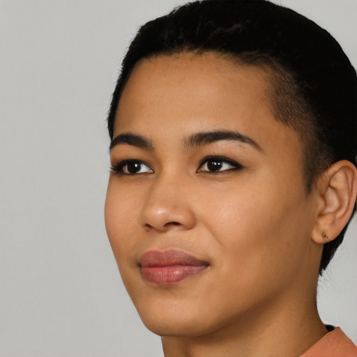 Joyful latino young-adult female with short  black hair and brown eyes