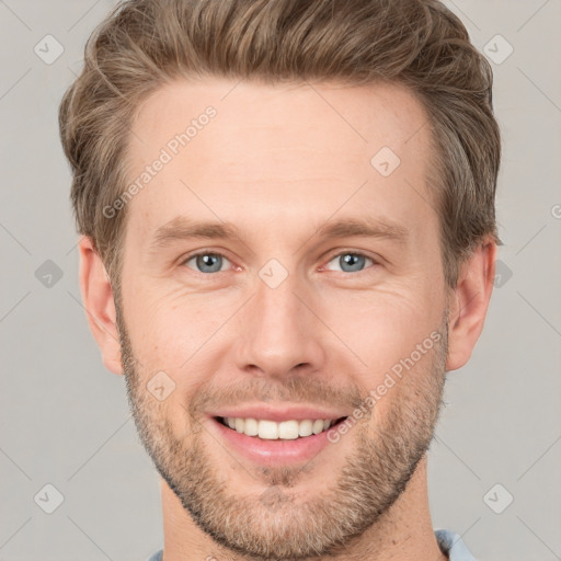 Joyful white young-adult male with short  brown hair and grey eyes