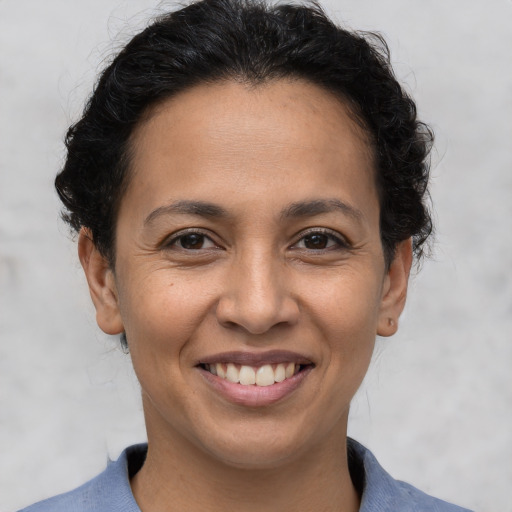 Joyful latino young-adult female with short  brown hair and brown eyes