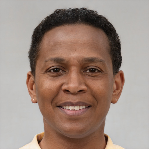 Joyful black adult male with short  brown hair and brown eyes