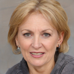 Joyful white adult female with medium  brown hair and blue eyes