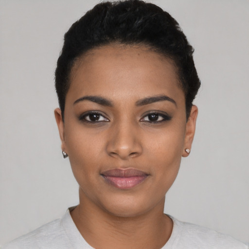 Joyful black young-adult female with short  black hair and brown eyes