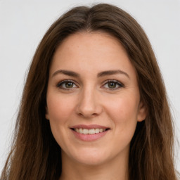 Joyful white young-adult female with long  brown hair and green eyes