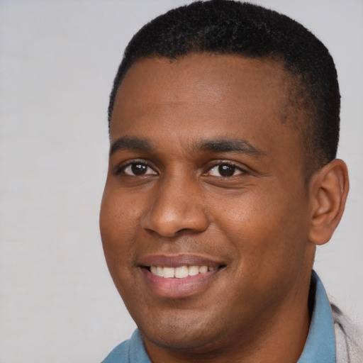 Joyful black young-adult male with short  brown hair and brown eyes