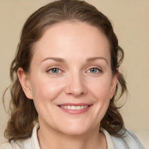 Joyful white young-adult female with medium  brown hair and blue eyes