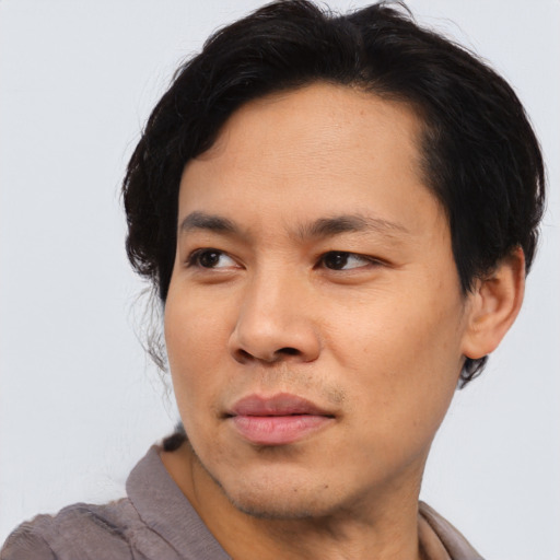 Joyful asian young-adult male with short  brown hair and brown eyes