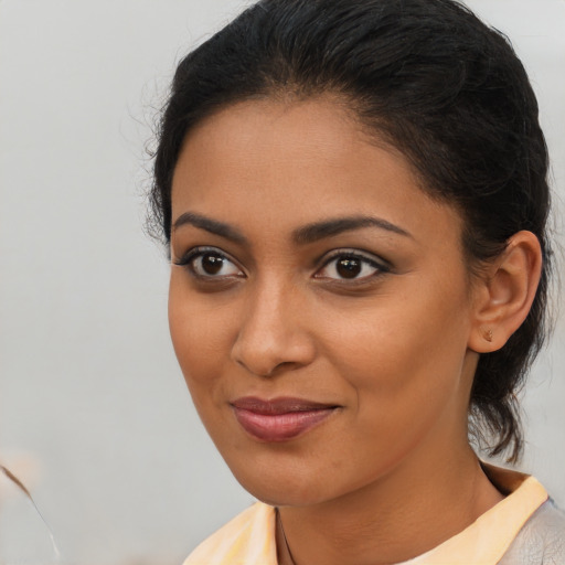 Joyful latino young-adult female with medium  brown hair and brown eyes