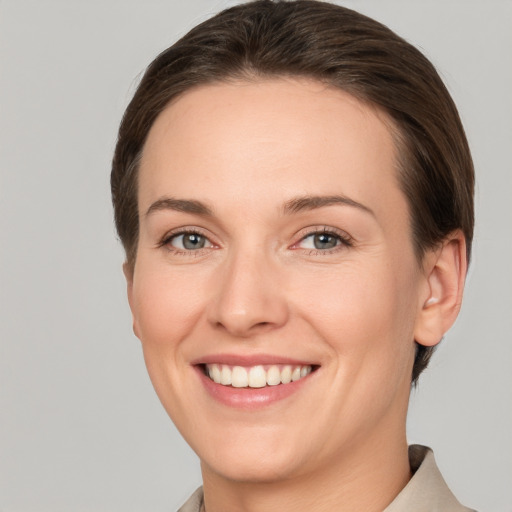 Joyful white young-adult female with short  brown hair and grey eyes